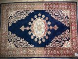 an image of a blue rug with a red border on a floor