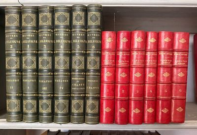 de nombreux livres qui se trouvent sur une étagère dans une bibliothèque
