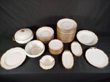 a lot of white and gold plates and bowls on the table