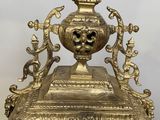 une horloge en or surmontée d'un visage