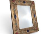 an image of a gold framed mirror with blue and red stones