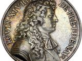 a silver coin with a portrait of a man with long hair