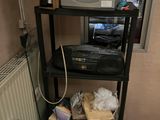 a black shelf with a laptop and a printer on top of it