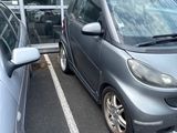 two cars parked in a parking lot next to each other