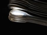 a lot of silver spoons stacked on top of each other