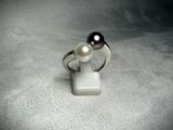 a ring with a pearl on it sitting on a table