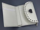 portefeuille en cuir avec une couverture en cuir blanc et un bouton en cuir noir