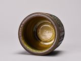 a close up of a brown vase on a white surface