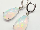 une paire de boucles d'oreilles en oplite et diamants sur fond blanc