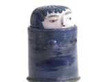 un petit vase bleu orné d'un visage blanc