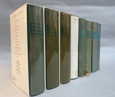 several books are lined up in a row on a white surface