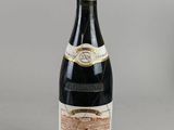 une vieille bouteille de vin posée sur une table à côté d'une bouteille de vin