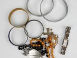 de nombreux bracelets et bagues sur un fond blanc
