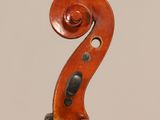 a close up of the back of a violin with a fiddle in the foreground