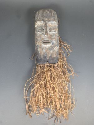 une image représentant un masque en bois sur lequel poussent des racines