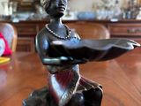 a figurine of a woman sitting on top of a wooden table