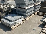 a pile of concrete blocks sitting on pallets in a yard