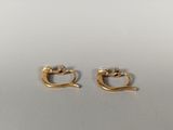 two pairs of gold plated earrings on a white surface
