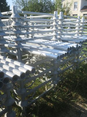de nombreux tuyaux qui traînent dans l'herbe près de la clôture