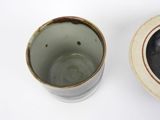 a white cup and a brown cup sitting next to each other