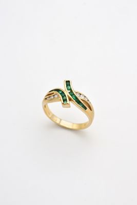 a gold ring with emerald stones and diamonds