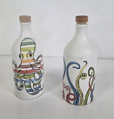 two bottles with octopus designs on them on a white surface