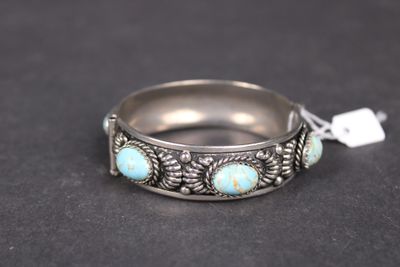 un gros plan d'une bague en argent sertie de pierres de turquoise