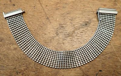 a close up of a metal bracelet on a wooden surface