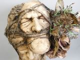 une sculpture représentant un homme avec un bouquet de fleurs sur la tête