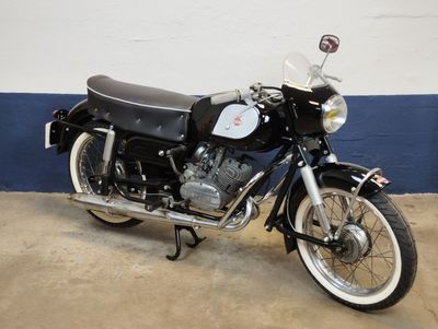 a black motorcycle parked in a garage with a blue wall