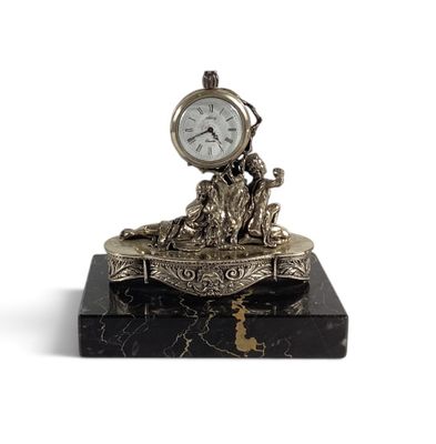 une horloge posée sur un bloc de marbre