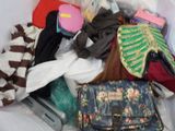 a pile of clothes and a purse on a bed