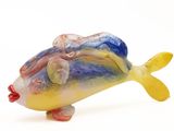 une figurine de poisson en verre posée sur une surface blanche