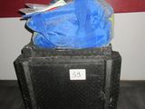 un sac bleu posé sur une valise noire