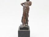 une image représentant une statue en bronze d'une femme posée sur un socle en marbre