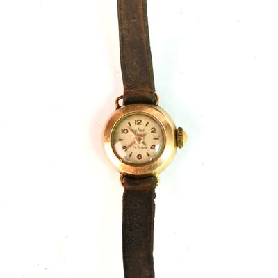 une montre montée sur un bracelet en cuir marron