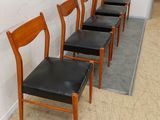 four chairs lined up against a wall in a row