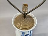 a blue and white vase with a gold lid