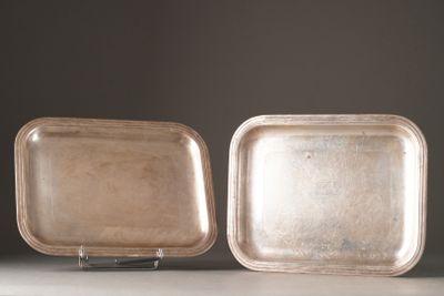 two silver trays sitting on top of a table next to each other