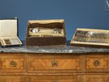une commode en bois sur laquelle sont posés des couverts en argent