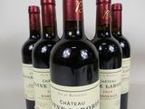 four bottles of wine are lined up on a table
