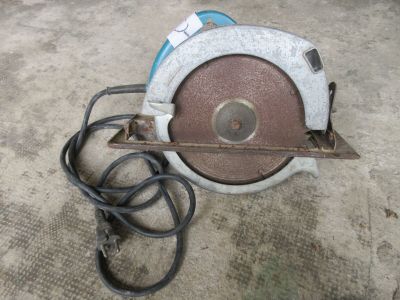 Quelqu'un utilise une scie circulaire pour couper un morceau de métal.