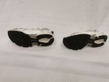 two pairs of black and white sneakers on a white surface