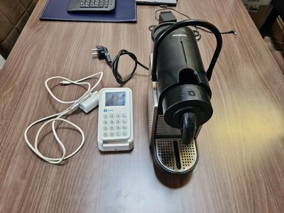 une table sur laquelle se trouvent un téléphone portable, un autre téléphone portable et une cafetière