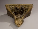 an ornate gold and black box with a lion head on it