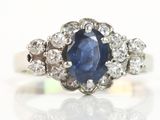 une photo d'une bague en saphir et diamants posée sur une surface blanche