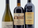 trois bouteilles de vin sont alignées sur une surface blanche