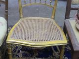 two chairs with cane back cushions and a blue rug in a room