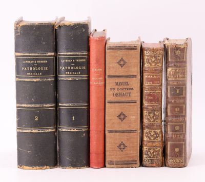 plusieurs vieux livres sont alignés sur une surface blanche