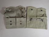 two pieces of cloth with metal buttons and zippers sitting on a table